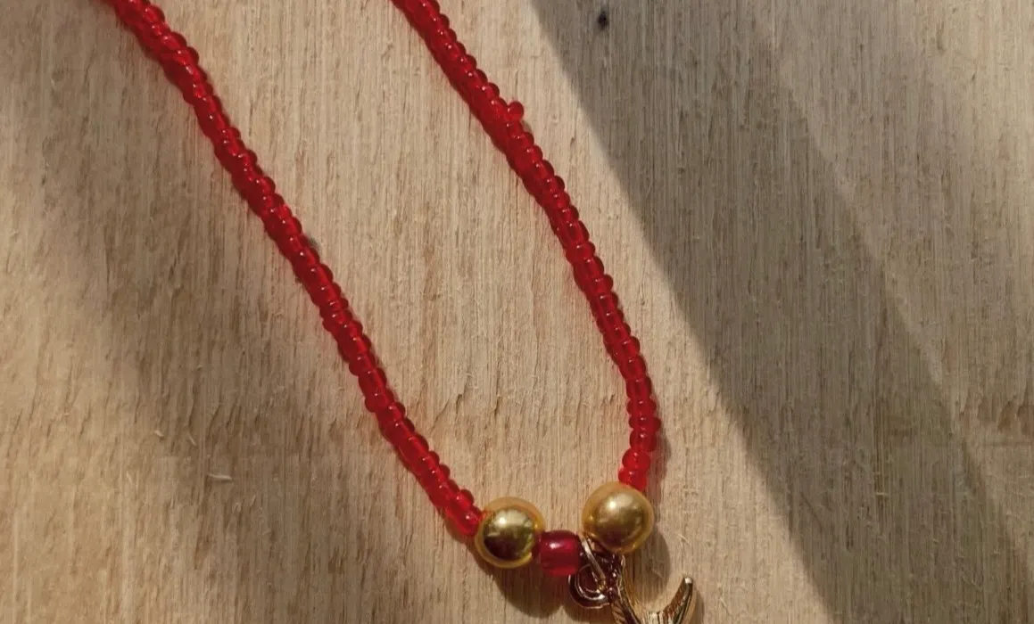 Collana di perline rosse con ciondolo a stella marina